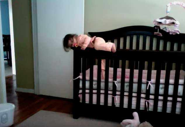 Ребенок перелазит через борты детской кроватки
