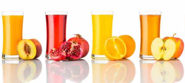 Персиковый, гранатовый, апельсиновый, яблочный соки в стаканах и соответствующие фрукты возле них