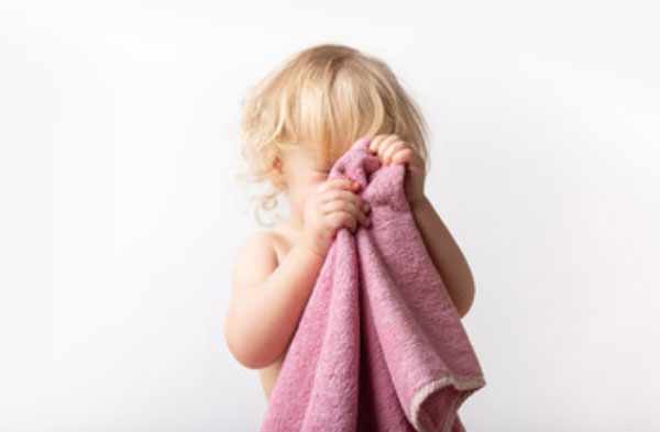 Ребенок вытирает лицо полотенцем