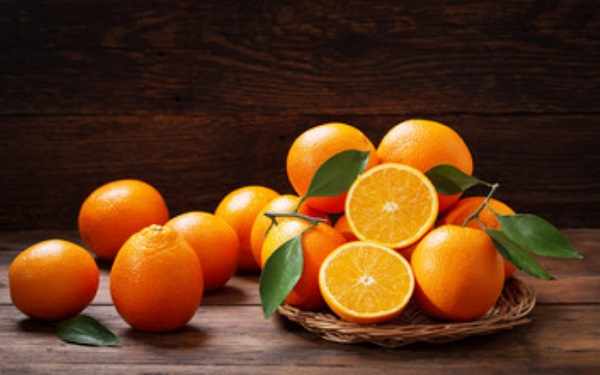 Апельсины на тарелке и на столе
