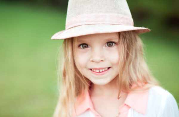 Пятилетняя девочка в шляпке. Она улыбается