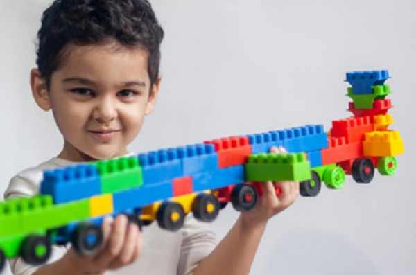 Ребенок держит поезд, построенный из конструктора