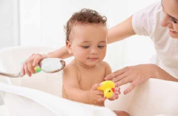 Ребенок играет резиновой уточкой при приеме ванны