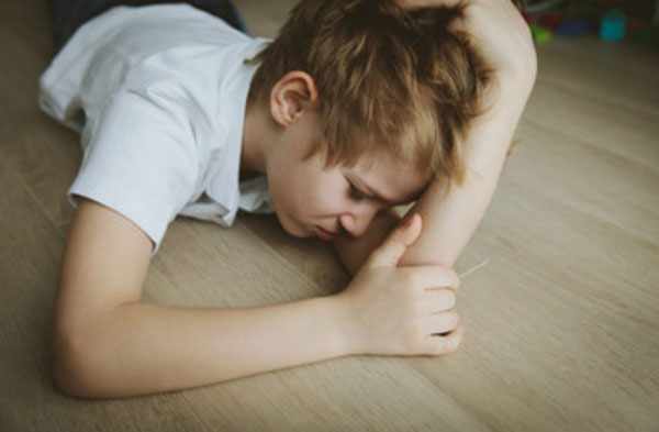 Расстроенный мальчик лежит на полу