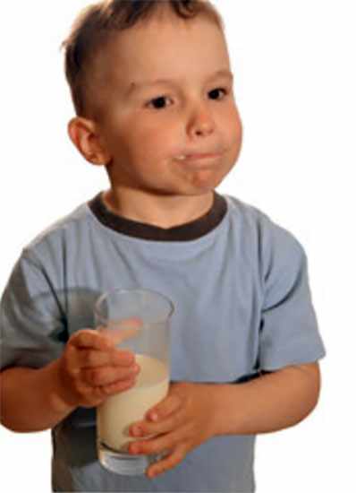 Недовольный мальчик со стаканом молока