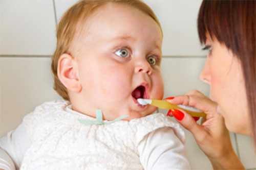 Мама чистит зубы маленькому малышу