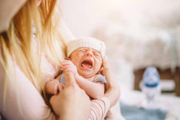 Новорожденный плачет на руках у мамы