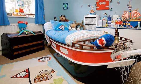 Кровать в виде корабля, на комоде корабль, на полу стоит сундук, на нем осьминог