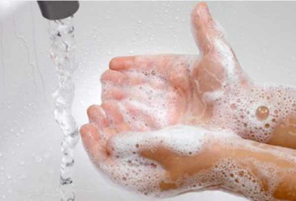 Мыльные руки ребенка возле струи воды
