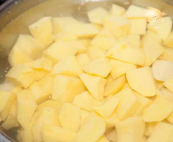 Покрошенный картофель в в кастрюле с водой