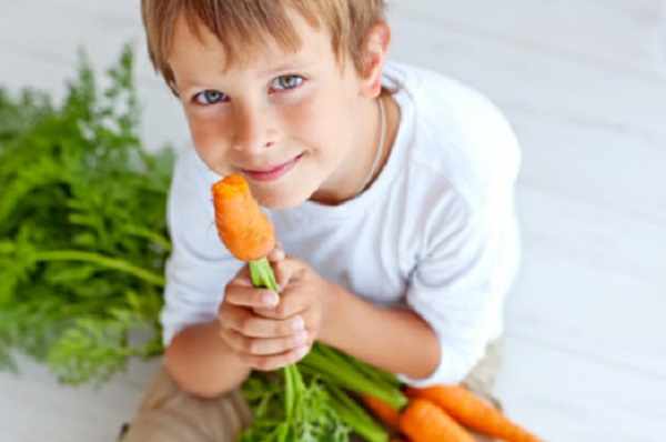 Мальчик грызет морковку