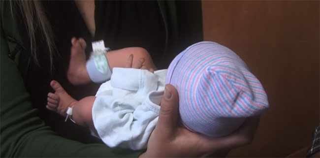Папа держит новорожденного на руках