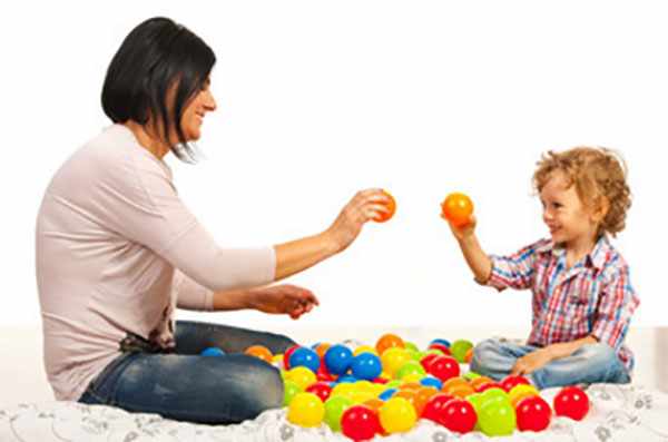 Мама с сыном сидят на полу, между ними разноцветные мячики