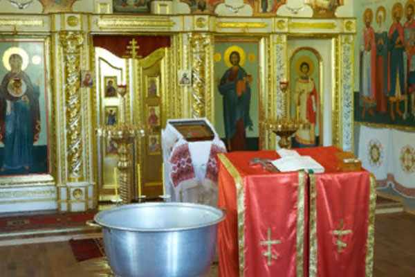Библия, православный крест и чаша, приготовленные для церемонии крещения