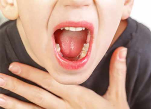 Мальчик с открытым ртом держится за горло, которое сильно болит