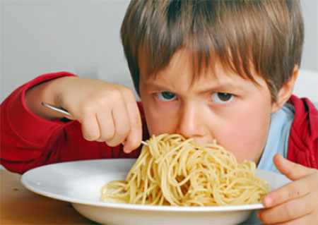 Ребенок ест большую порцию макарон 