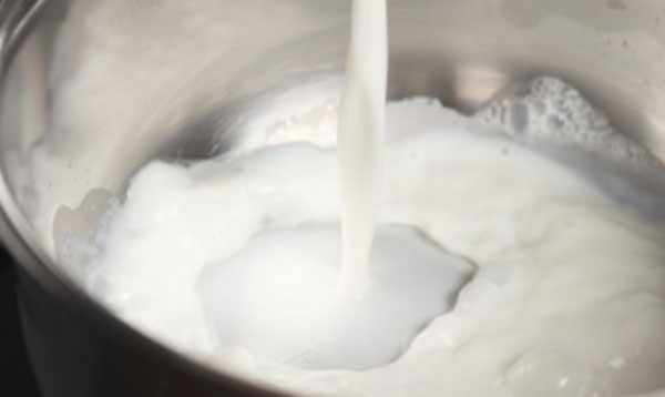 Наливание молока в кастрюлю