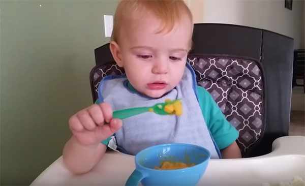 Ребенок ест ложкой