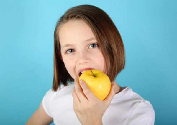 Девочка грызет яблоко