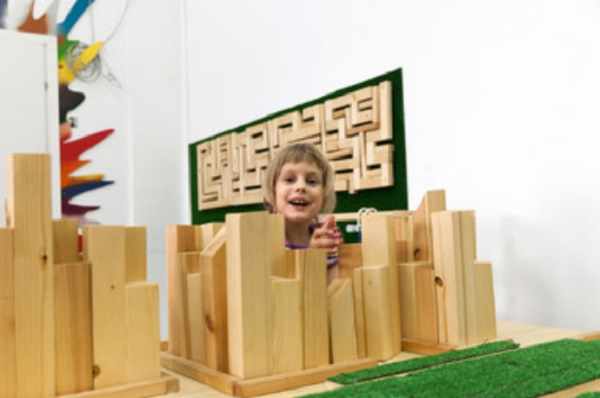 Девочка строит деревянный пазл