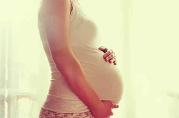 Женщина держит свой большой беременный живот
