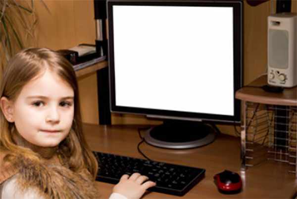 Девочка сидит возле персонального компьютера