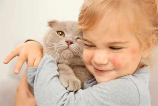 Девочка обнимает кота. У нее на лице аллергические пятна