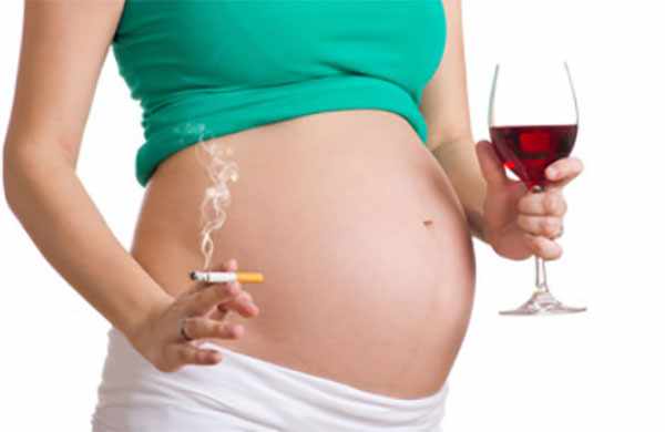 Беременная женщина с сигаретой и бокалом вина