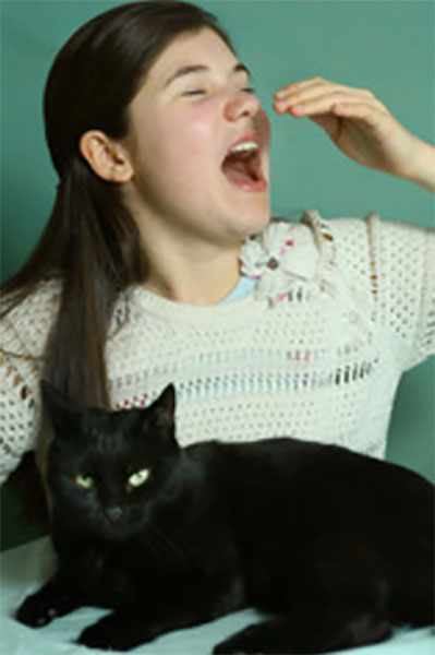 Девочка чихает, перед ней сидит кот