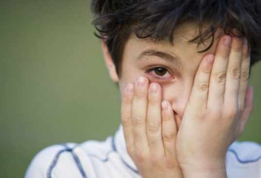 Мальчик с воспаленными глазами, прикрывает рукой один глаз