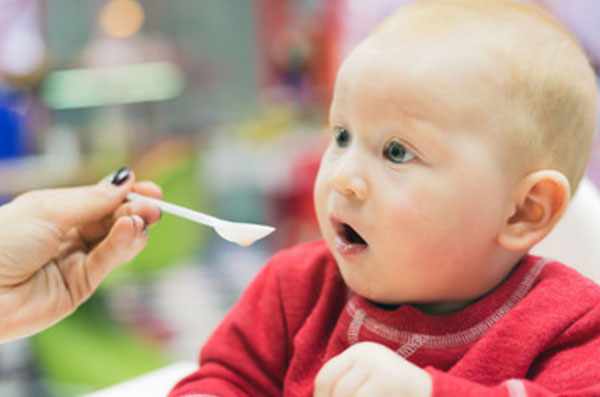 Ребенка кормят с ложечки