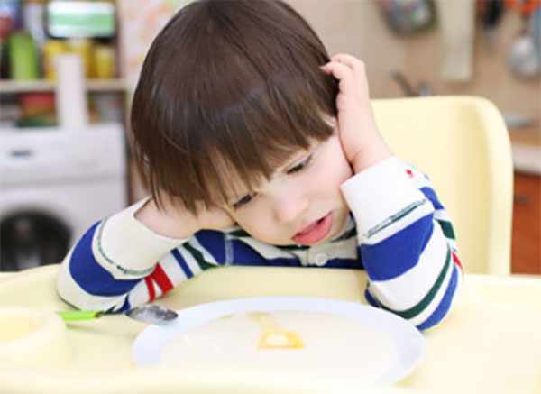 Ребенок не хочет есть, сидит перед тарелкой с едой
