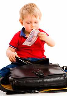 Ребенок вытаскивает деньги из сумки