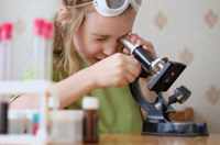 Девочка смотрит в микроскоп